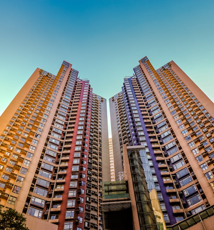 gallery-01 Tall, colorful skyscrapers reaching into the blue sky in Hong Kong, showcasing modern architecture.